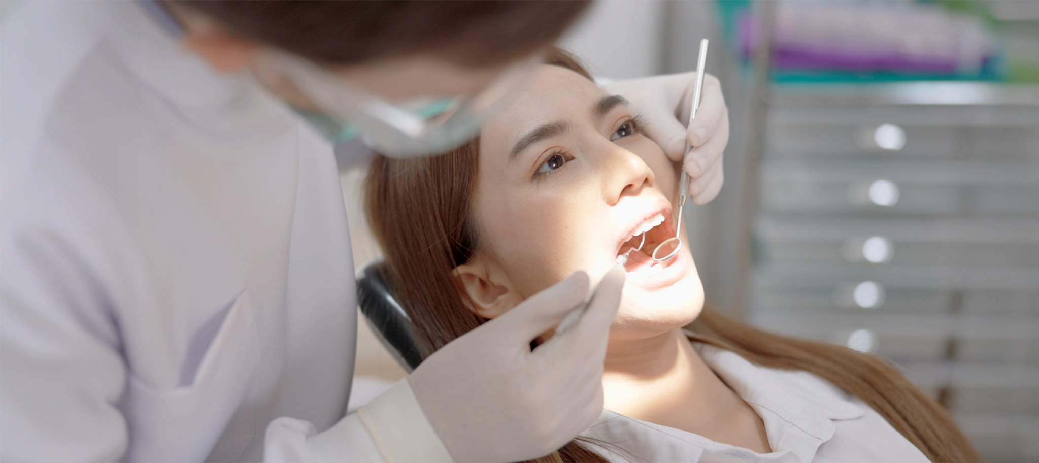 Dentist performing a dental checkup on a female patient at Dr Clear Aligners clinic, showcasing care and professionalism