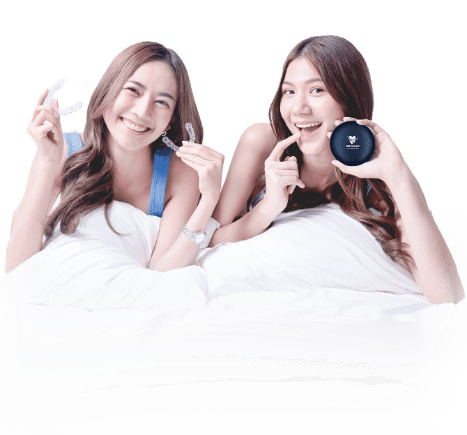 Two women smiling with clear aligners and Dr Clear Aligners case on bed