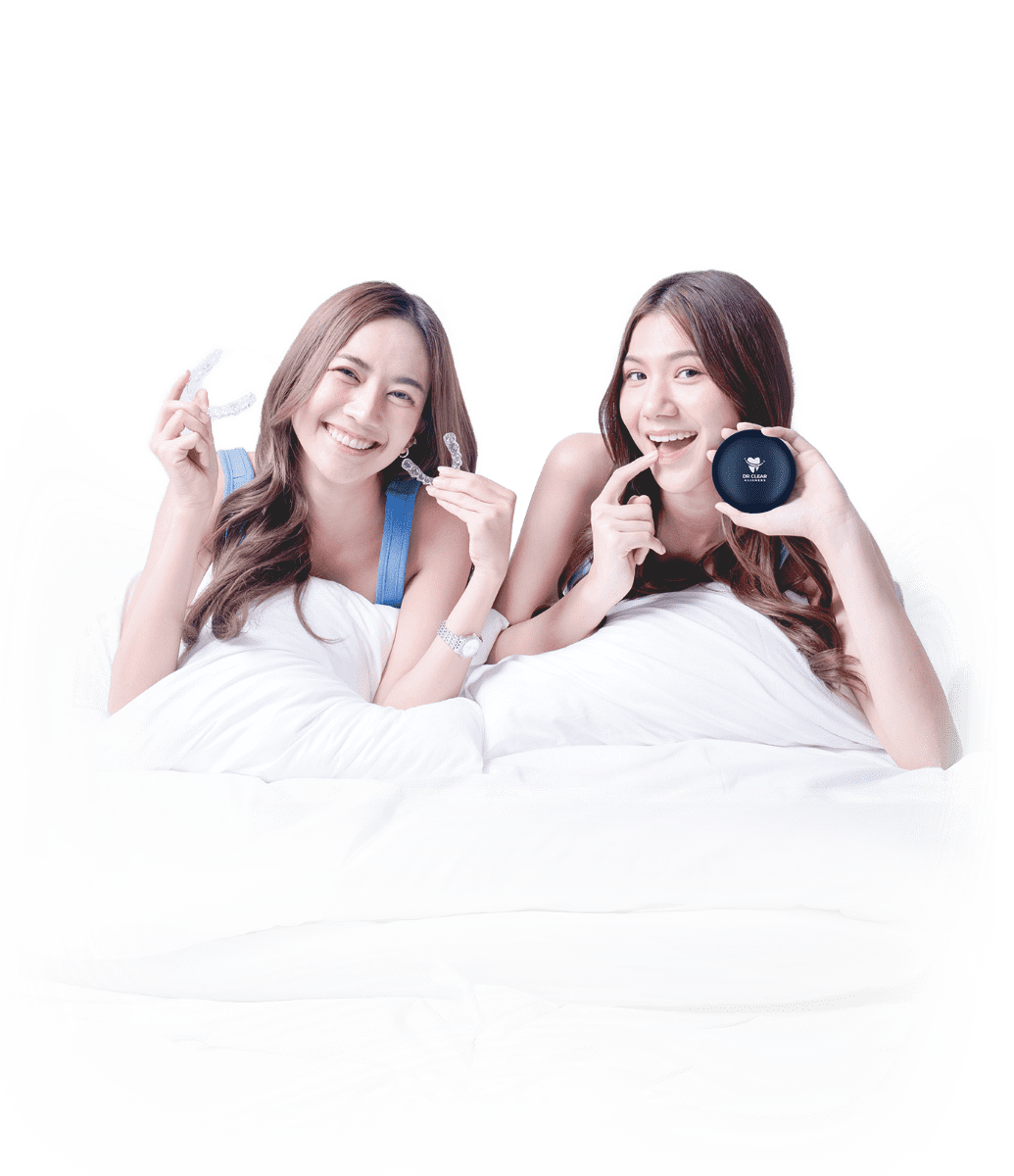 Two women smiling with clear aligners and Dr Clear Aligners case on bed