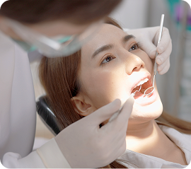 Young woman putting on retainer in front of mirror to maintain teeth alignment