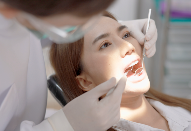 Dentist performing a dental checkup on a female patient at Dr Clear Aligners clinic, showcasing care and professionalism